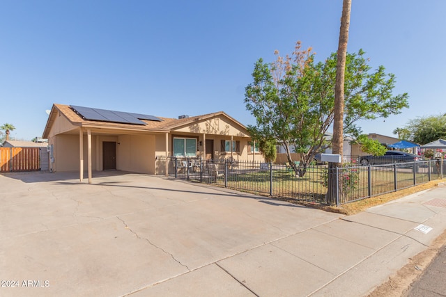 single story home with solar panels and a front lawn