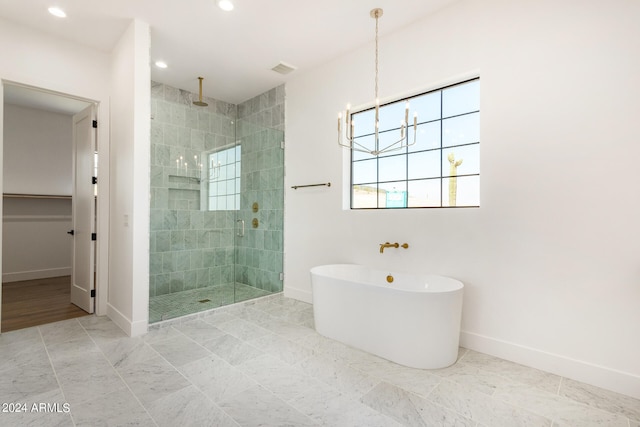 bathroom with plus walk in shower and a chandelier