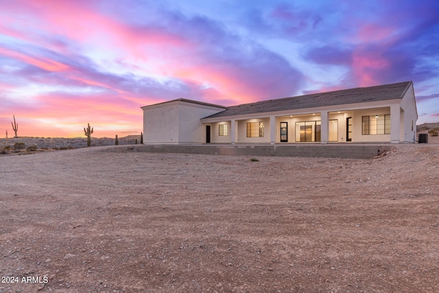 rear view of house featuring stucco siding and central AC