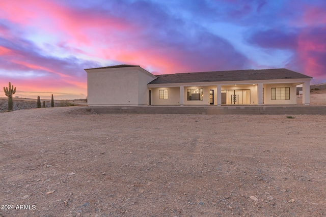 back of house at dusk with stucco siding