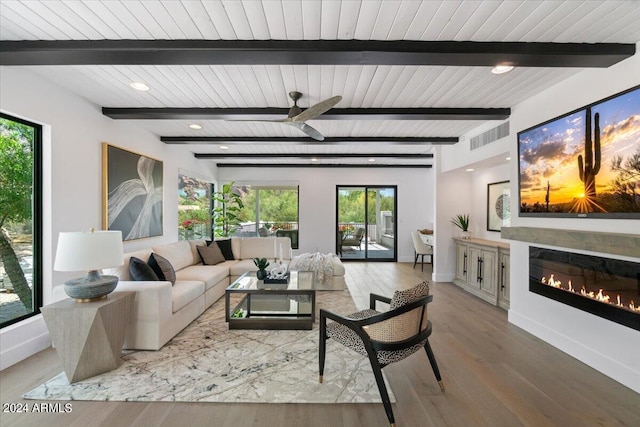 living room featuring ceiling fan, beam ceiling, and wood-type flooring