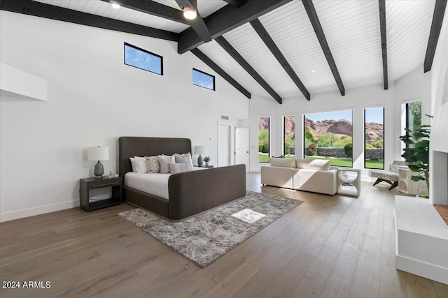 bedroom with beam ceiling, high vaulted ceiling, and wood-type flooring