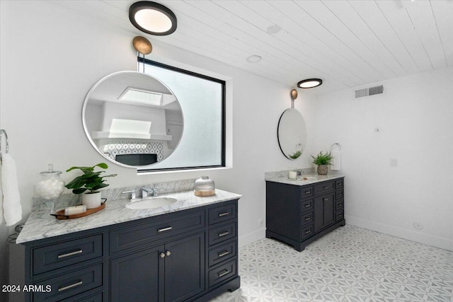 bathroom with tile flooring, oversized vanity, and dual sinks