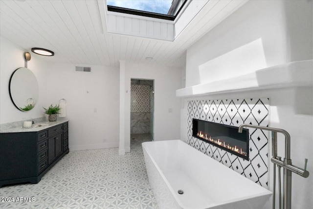 bathroom featuring tile floors, a tiled fireplace, plus walk in shower, and vanity