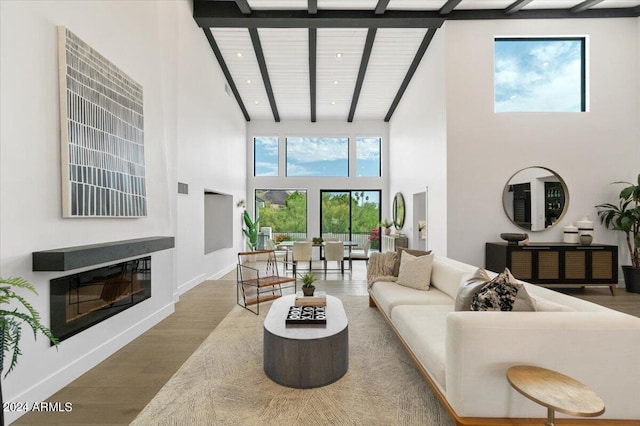 living room featuring beamed ceiling, high vaulted ceiling, and hardwood / wood-style flooring