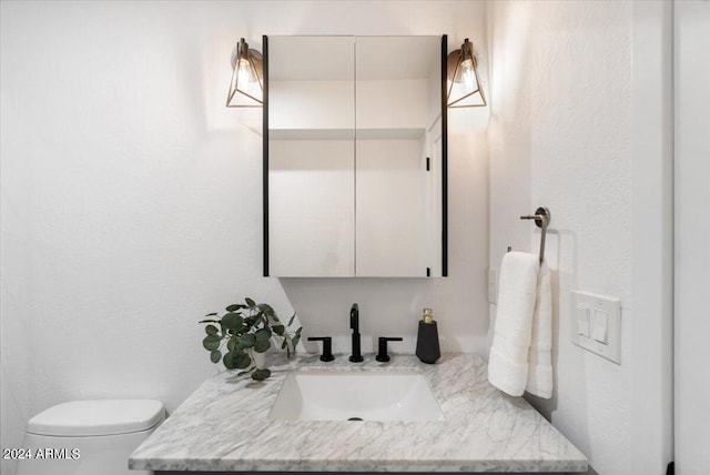 bathroom featuring vanity with extensive cabinet space and toilet