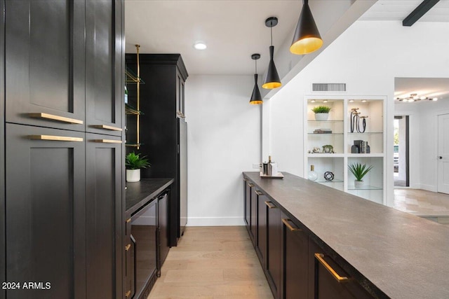 kitchen with beam ceiling, hanging light fixtures, and light wood-type flooring