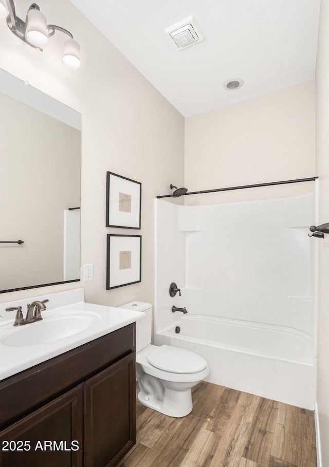 full bathroom featuring toilet, shower / bathtub combination, wood-type flooring, and vanity