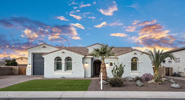 mediterranean / spanish home featuring a lawn and a garage