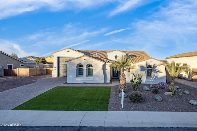 mediterranean / spanish-style house with a front lawn and a garage