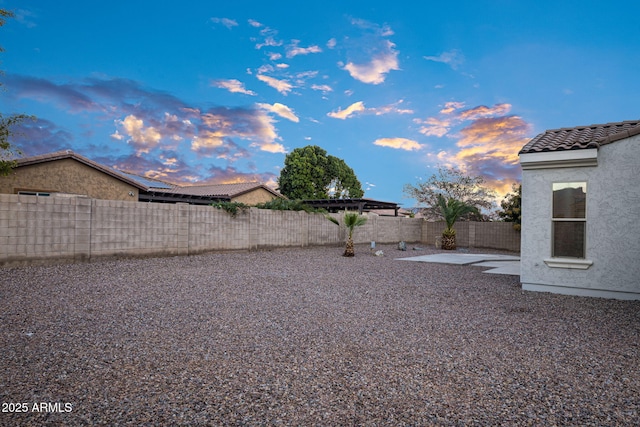 yard at dusk featuring a patio area