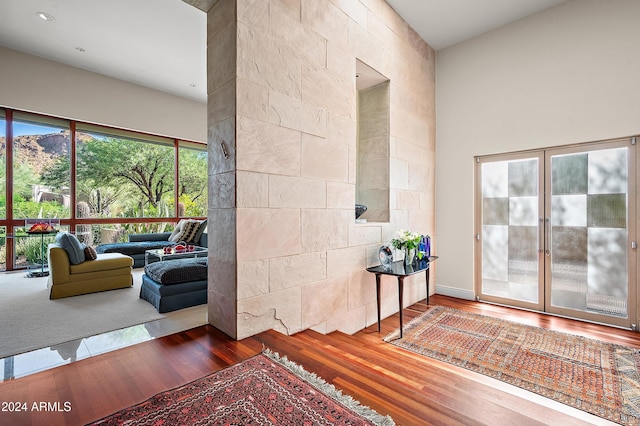 interior space with a towering ceiling and wood finished floors