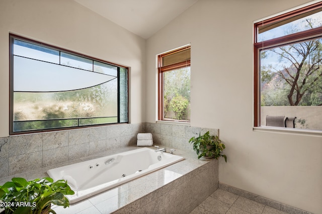 full bathroom featuring baseboards, vaulted ceiling, and a tub with jets