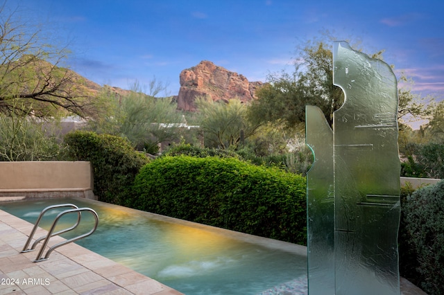 view of pool with a patio and a mountain view