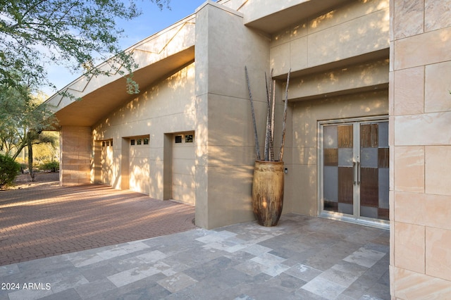 view of side of home with a garage and french doors