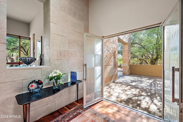 entryway featuring wood finished floors and tile walls