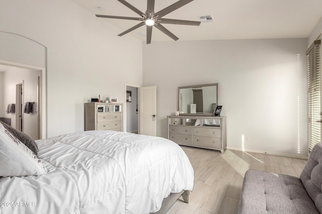 bedroom with ceiling fan, high vaulted ceiling, visible vents, baseboards, and light wood finished floors