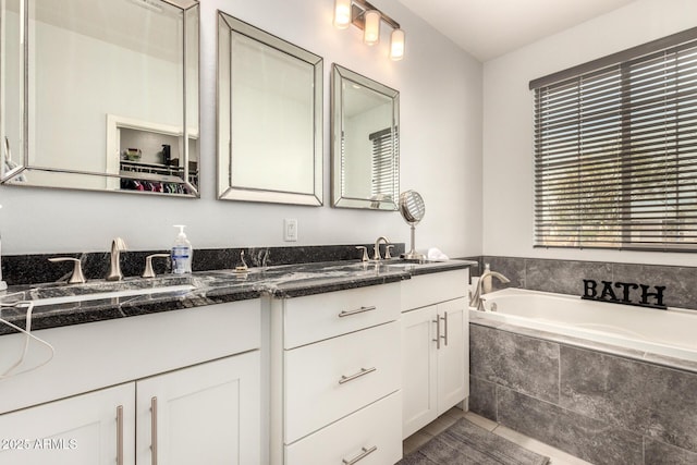 full bath with a garden tub, double vanity, and a sink