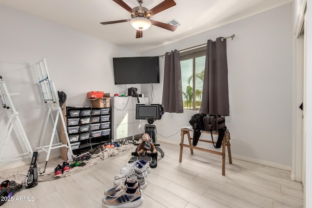 workout area with baseboards, wood finished floors, visible vents, and a ceiling fan