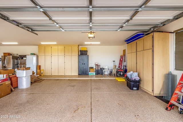 garage featuring stainless steel fridge and freestanding refrigerator