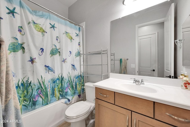 bathroom featuring toilet, shower / bath combo with shower curtain, and vanity