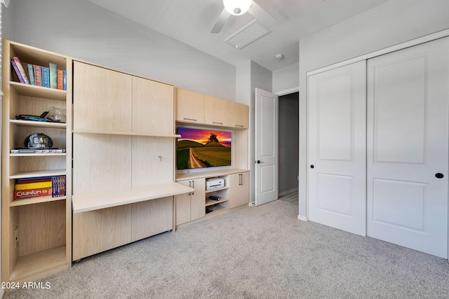 interior space featuring light carpet, ceiling fan, and a closet