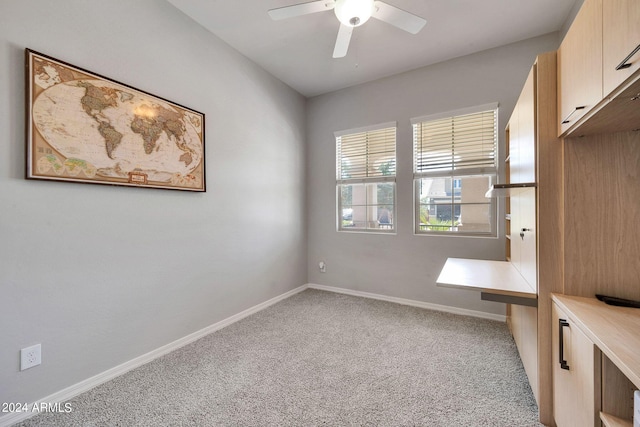 carpeted empty room with baseboards and a ceiling fan