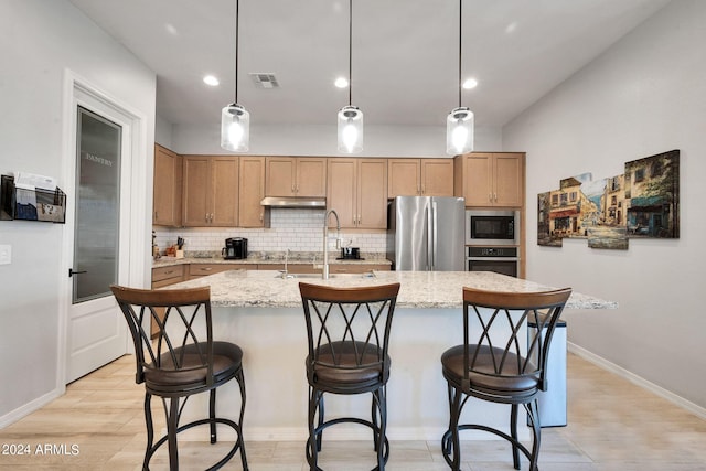 kitchen with stainless steel appliances, backsplash, visible vents, and under cabinet range hood