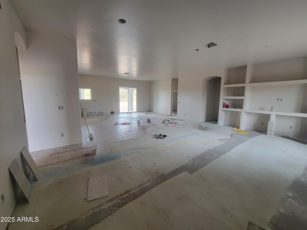 unfurnished living room featuring arched walkways