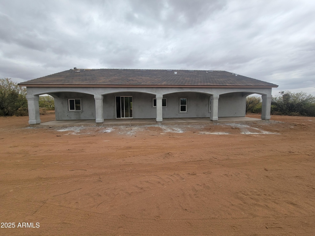 rear view of house featuring stucco siding