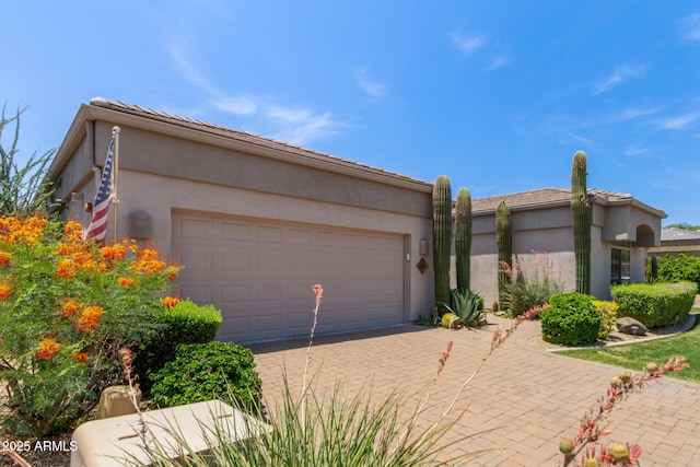 8689 E Krail St, Scottsdale, AZ 85250 - view of front of home featuring an attached garage, driveway, and stucco siding