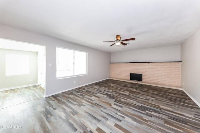 4833 N 63rd Ln, Phoenix, AZ 85033 - unfurnished living room featuring a ceiling fan, wood finished floors, and a fireplace