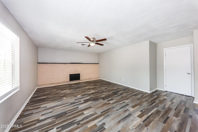4833 N 63rd Ln, Phoenix, AZ 85033 - unfurnished living room featuring ceiling fan, wood finished floors, and a brick fireplace