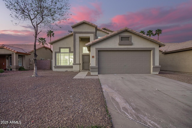 view of front of property with driveway, an attached garage, and stucco siding