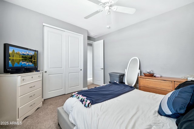 bedroom featuring ceiling fan, light colored carpet, and a closet