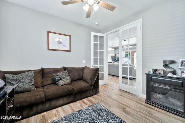 living room featuring ceiling fan, light wood-type flooring, and french doors