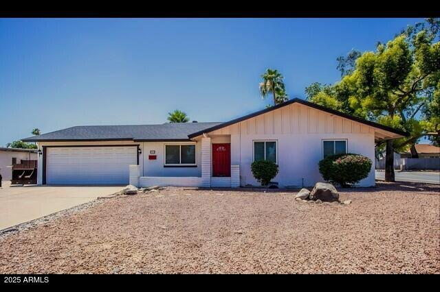 single story home featuring driveway, board and batten siding, and an attached garage