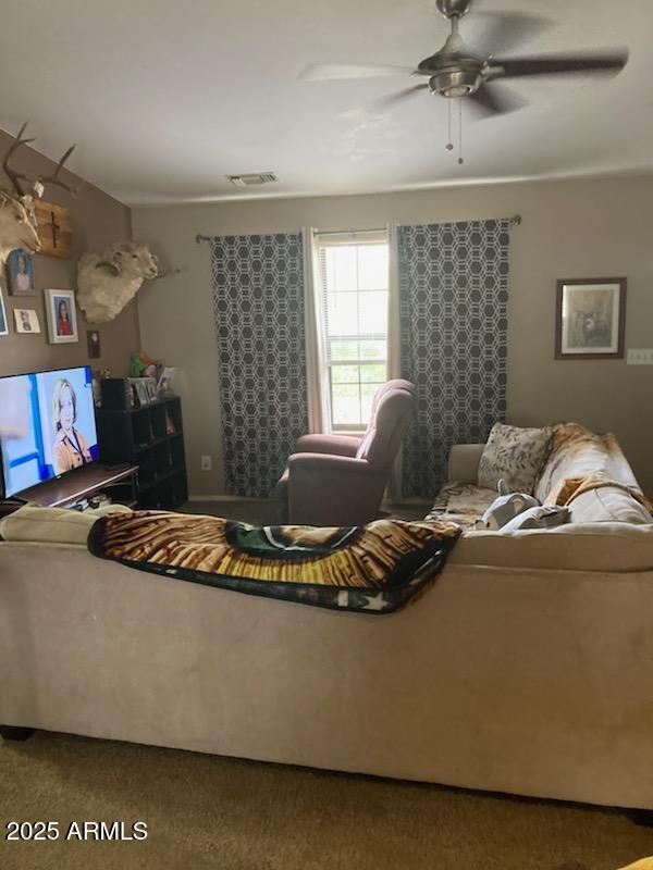 living room featuring carpet and ceiling fan