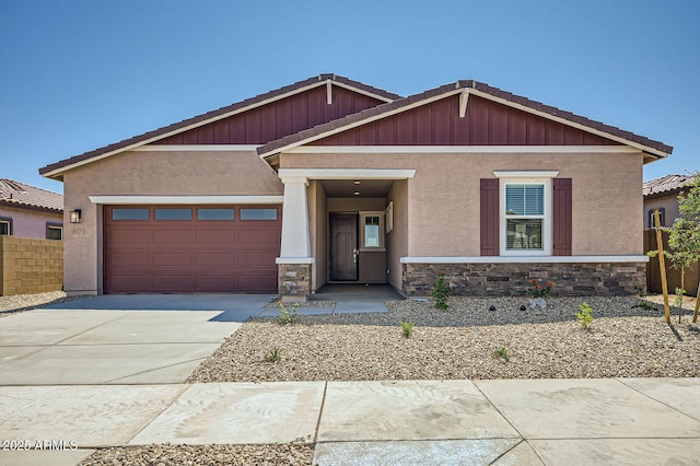 craftsman inspired home with a tile roof, stucco siding, a garage, and driveway