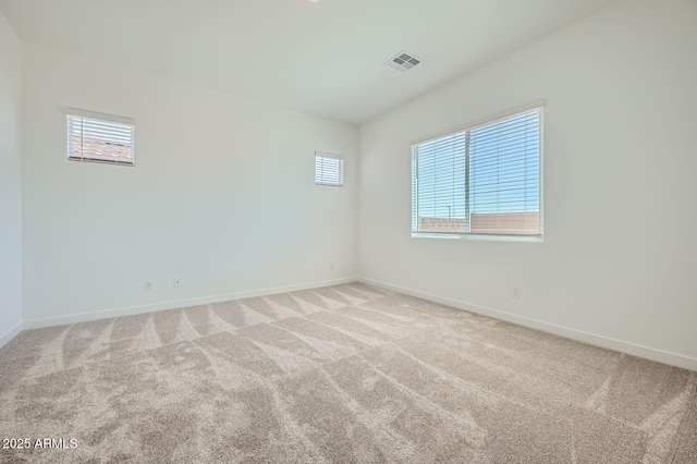unfurnished room featuring baseboards and light colored carpet