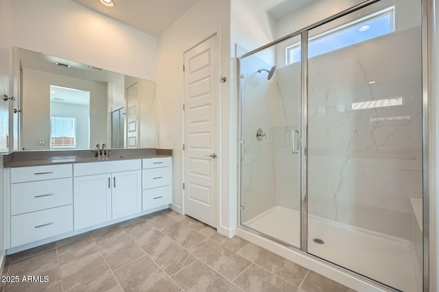 full bathroom with a marble finish shower and vanity