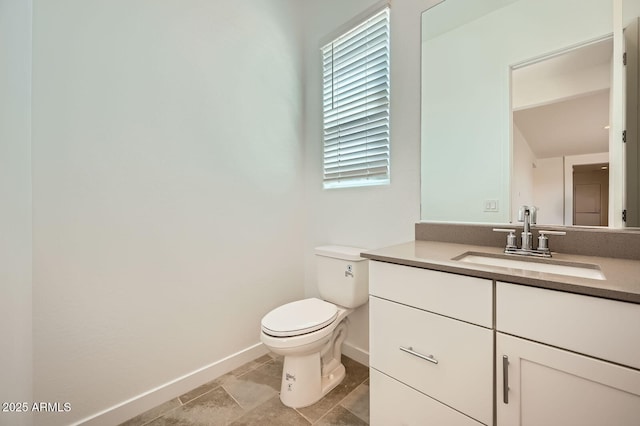 bathroom featuring baseboards, toilet, and vanity