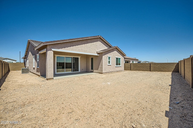 rear view of house featuring stucco siding and a fenced backyard