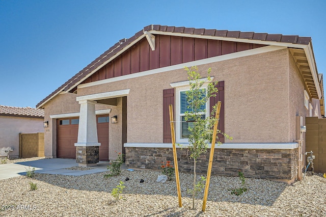 view of front facade featuring stone siding, board and batten siding, and a garage