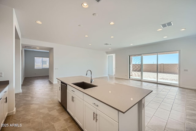 kitchen with a sink, stainless steel dishwasher, white cabinetry, recessed lighting, and baseboards