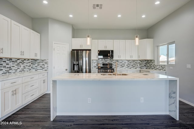 kitchen with white cabinetry, decorative light fixtures, a center island with sink, stainless steel appliances, and light stone countertops