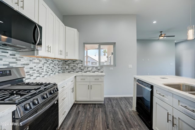 kitchen with appliances with stainless steel finishes, white cabinetry, light stone counters, tasteful backsplash, and dark hardwood / wood-style flooring