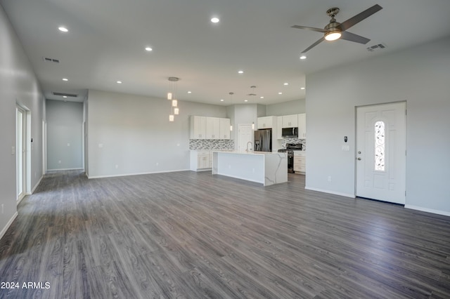 unfurnished living room with dark wood-type flooring and ceiling fan