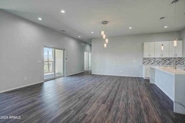 unfurnished living room with dark hardwood / wood-style flooring and sink