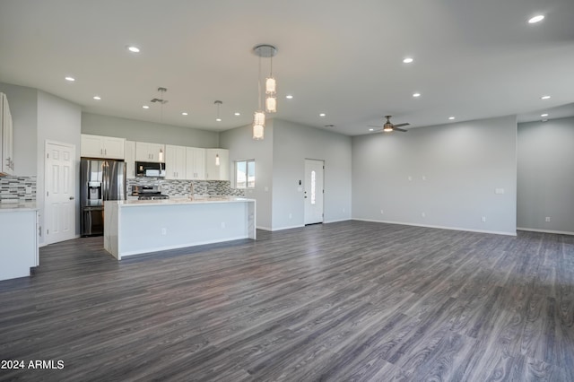 kitchen featuring tasteful backsplash, white cabinetry, pendant lighting, and stainless steel fridge